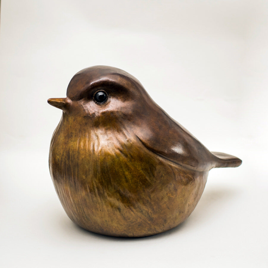 A very round, smooth Robin sculpture in bronze. Their cheat and belly are a lighter colour than the chocolate almost wood-like top of their back, tail and head. They have expressive black eyes and look very tactile due to smooth surfaces.