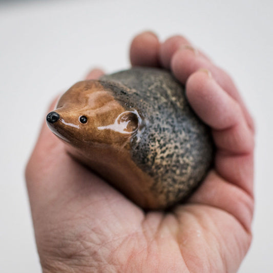 Small ceramic hedgehog held in a person's hand