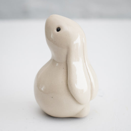 White Ceramic Bunny, a small, smooth, light-colored ceramic bunny figurine with black eyes
