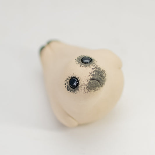 Ceramic Seal Pup Sculpture, light brown with black eyes and nose, viewed from above