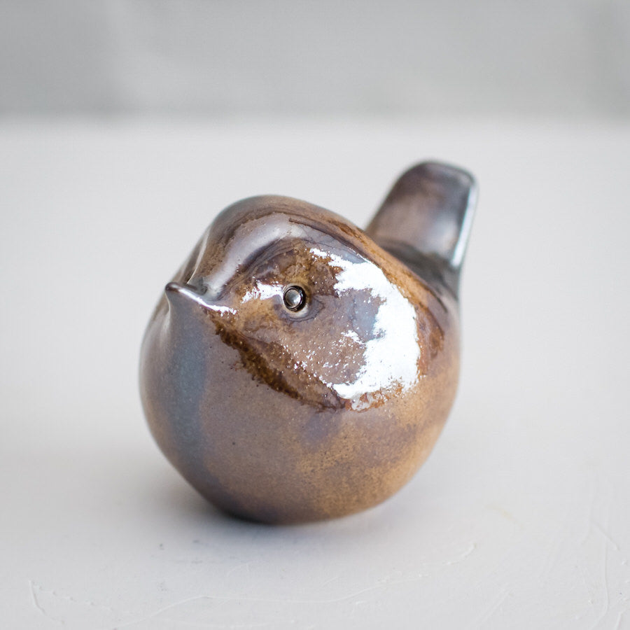 A shiny metallic brown, characterful ceramic sculpture of a little wren.