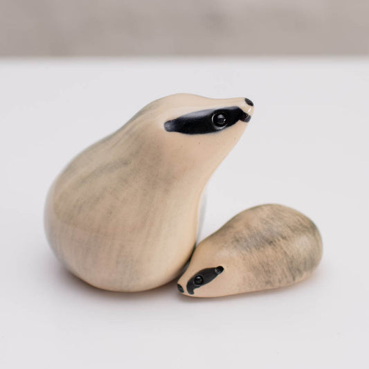 A small badger sculpture of a parent and cub against a white background