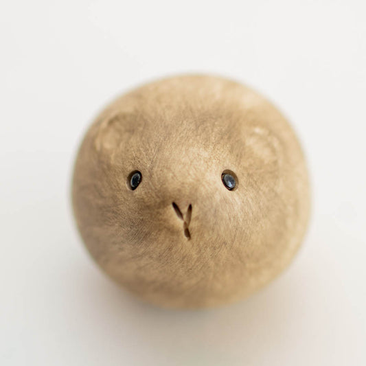 Vole Sculpture, a small, round, light brown wooden sculpture with two dark eyes and a carved V-shape for a nose