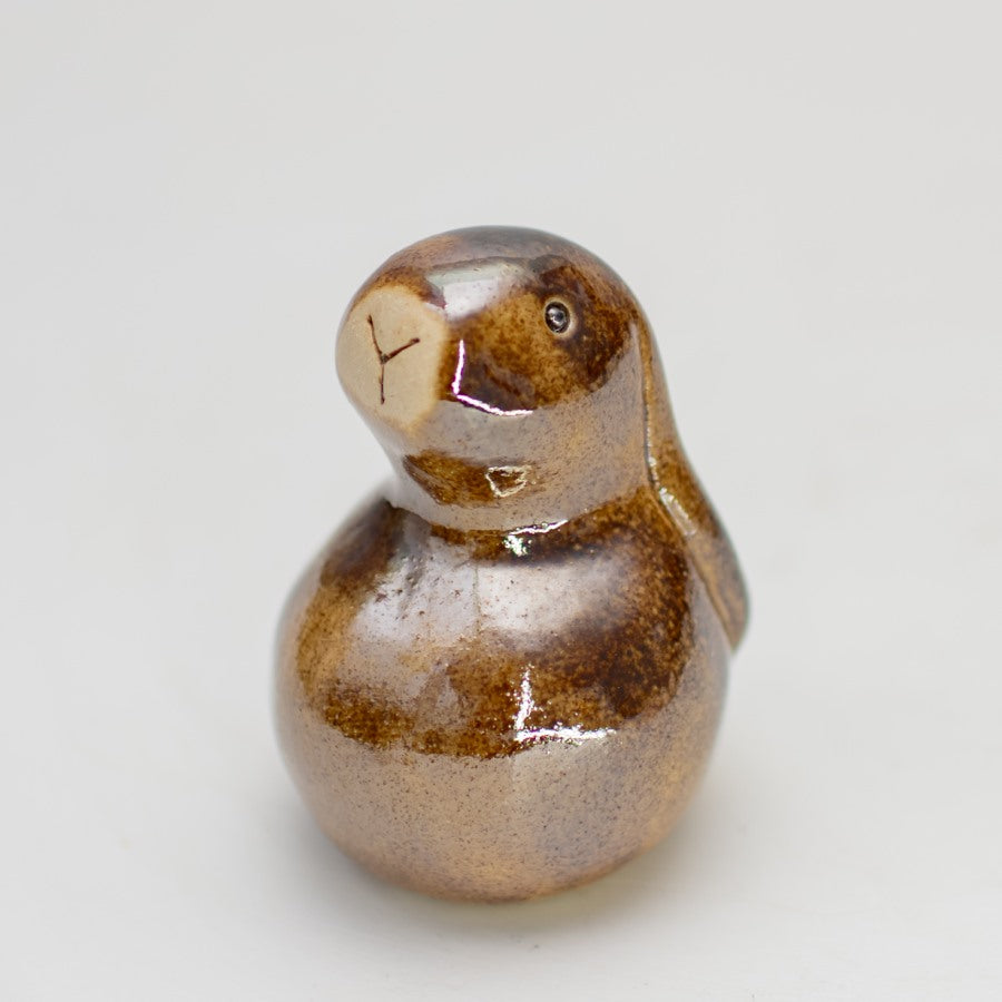 Small ceramic bunny sculpture in a brown metallic glaze