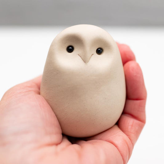 White Ceramic Owl Sculpture held in a person's palm