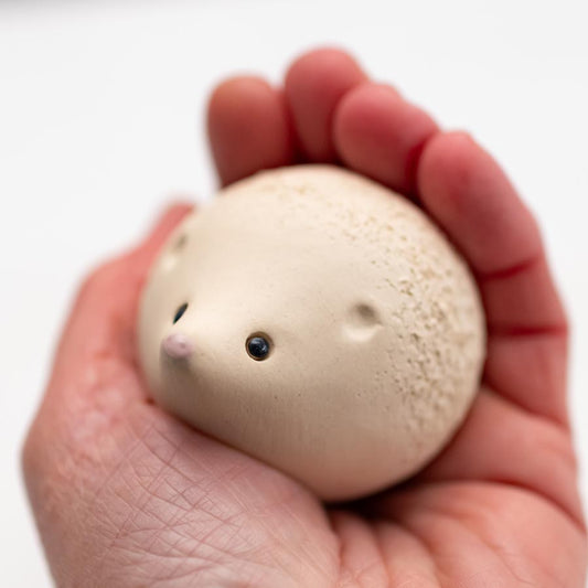 Snowy White Ceramic Hedgehog held in a person's palm