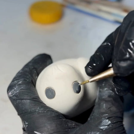 Hand glazing the eyes on a seal pup ceramic