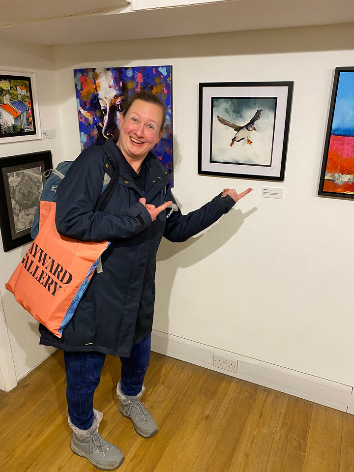 Sarah Brabbin pointing at her picture at the 2022 British Art Prize Exhibition
