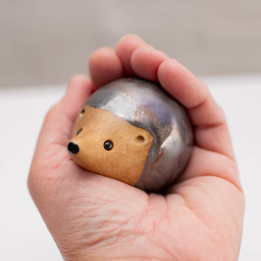 Ceramic hedgehogs - a larger hedgehog next to two smaller ones on a white background