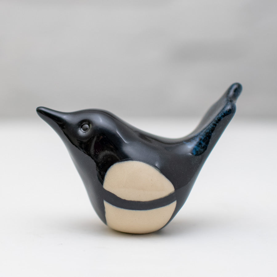 Small ceramic Magpie sculpture set against a white backdrop