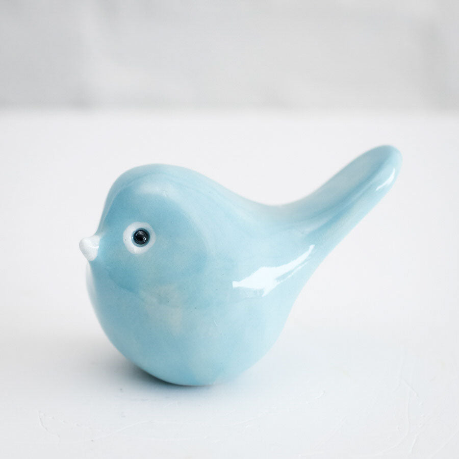 A glossy blue ceramic bird with a white beak