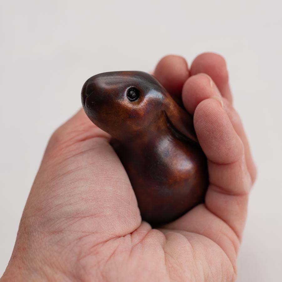 Small Brown Foundry Bronze Bunny Rabbit Sculpture in a hand against a white background