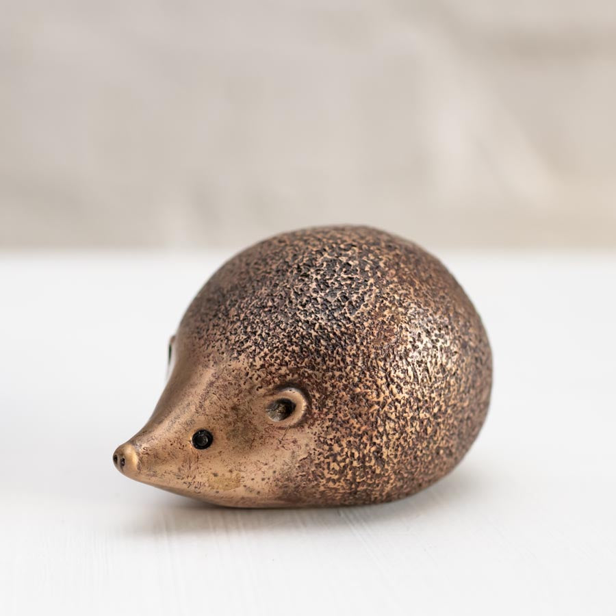 Bronze hedgehog sculpture on a white background