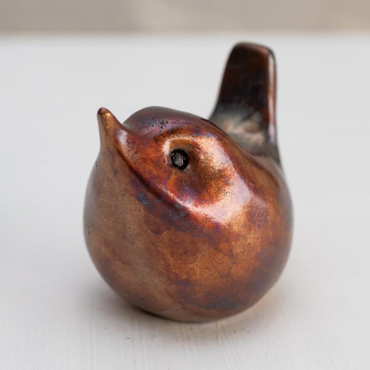 Small bronze wren sculpture against a white background