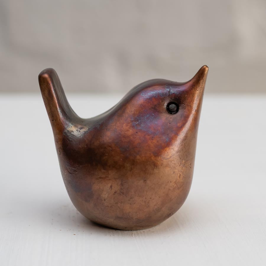 Small bronze wren sculpture against a white background