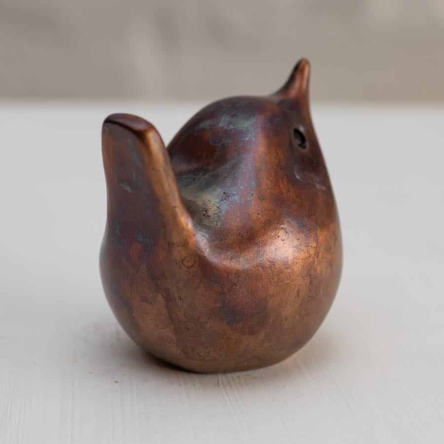 Small bronze wren sculpture against a white background