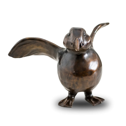 A bronze Puffin sculpture against a plain background