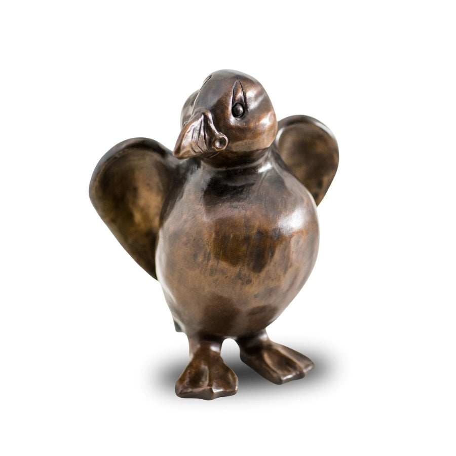 A bronze Puffin sculpture against a plain background