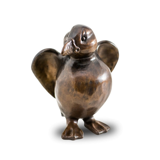 A bronze Puffin sculpture against a plain background