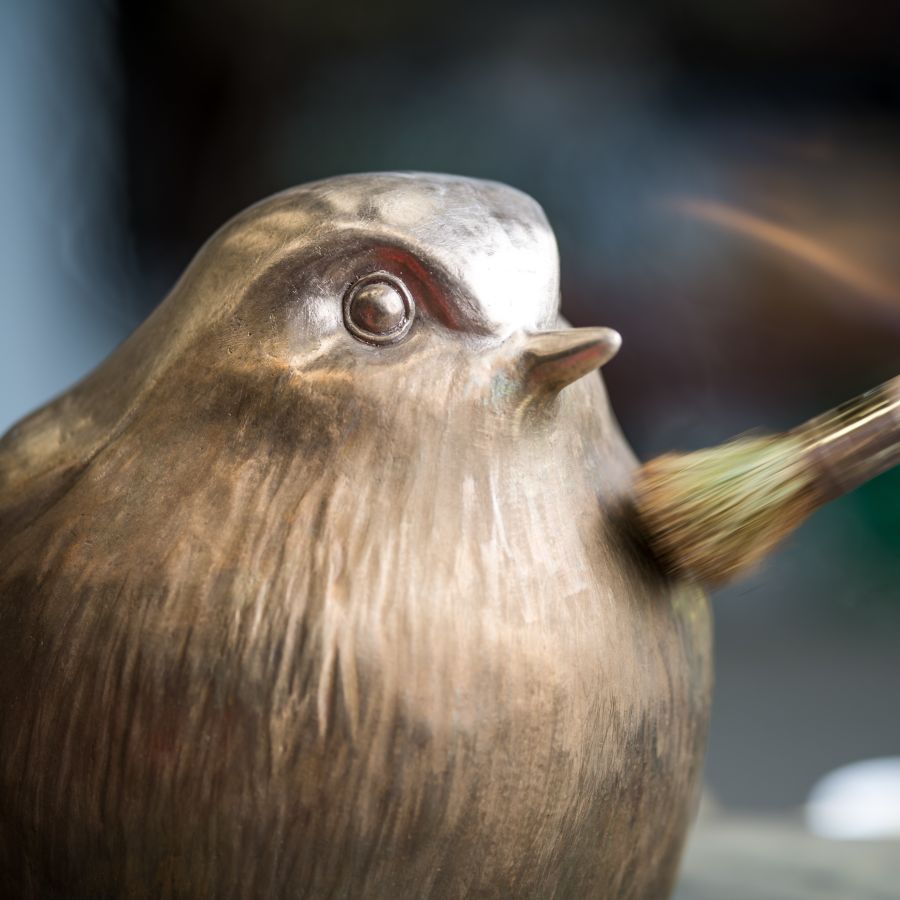Bronze Robin sculpture having its patina applied with a brush