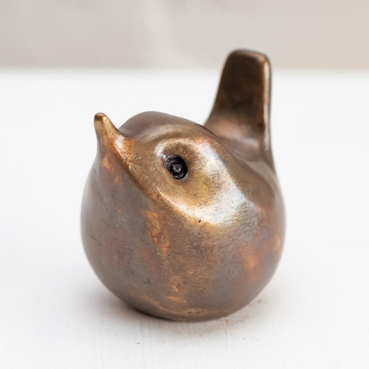 Small bronze wren sculpture against a white background