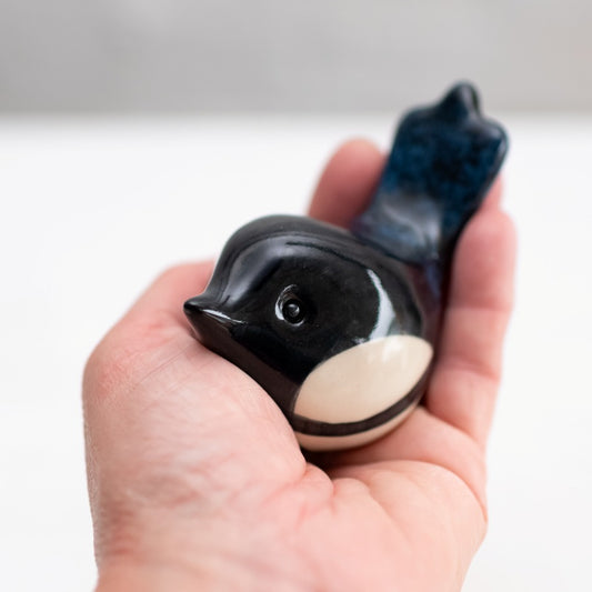 Small Ceramic Magpie Sculpture held in a hand