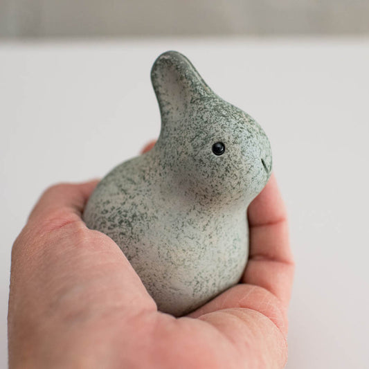 Small ceramic bunny sculpture in a hand