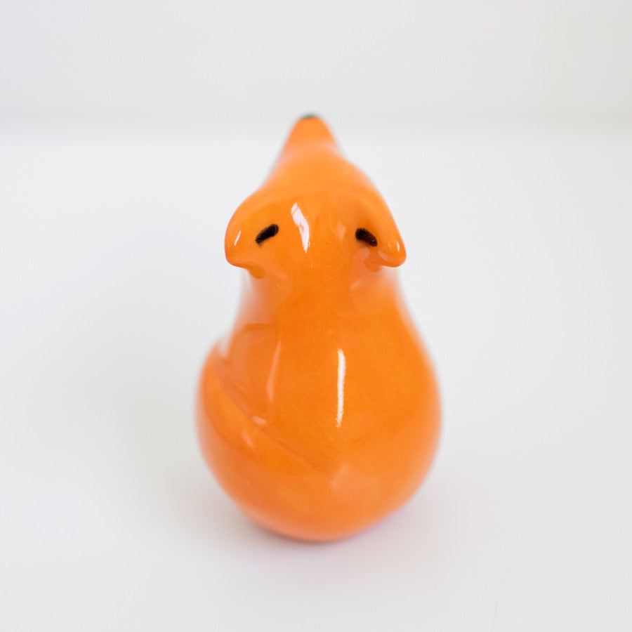 Back view of a small ceramic fox against a white background