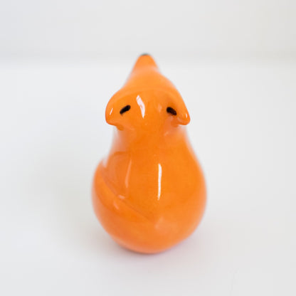 Back view of a small ceramic fox against a white background