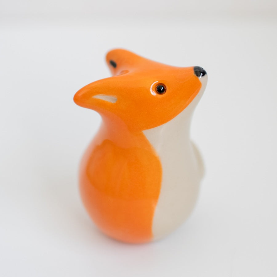 Small ceramic fox against a white background