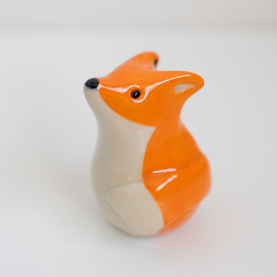 Small ceramic fox against a white background