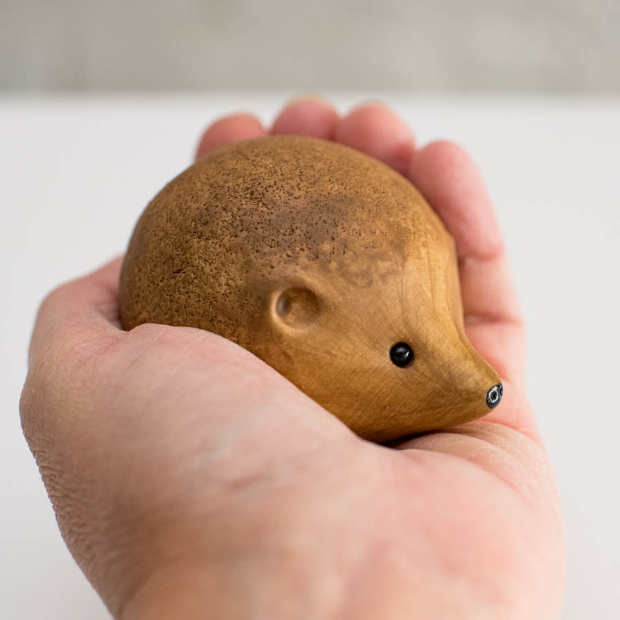Small ceramic hedgehog sculpture in a hand