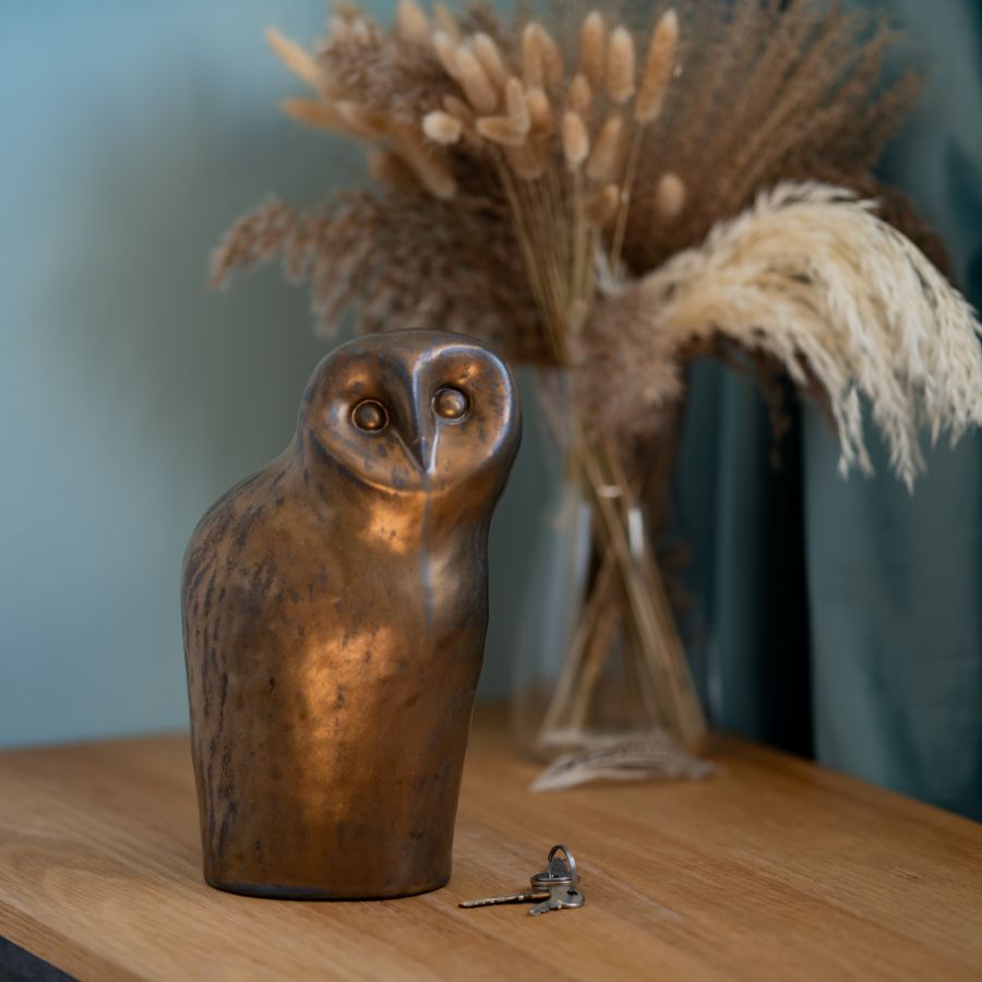 Large Ceramic Owl Sculpture on a wooden surface next to keys and dried flowers