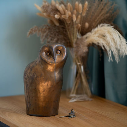 Large Ceramic Owl Sculpture on a wooden surface next to keys and dried flowers