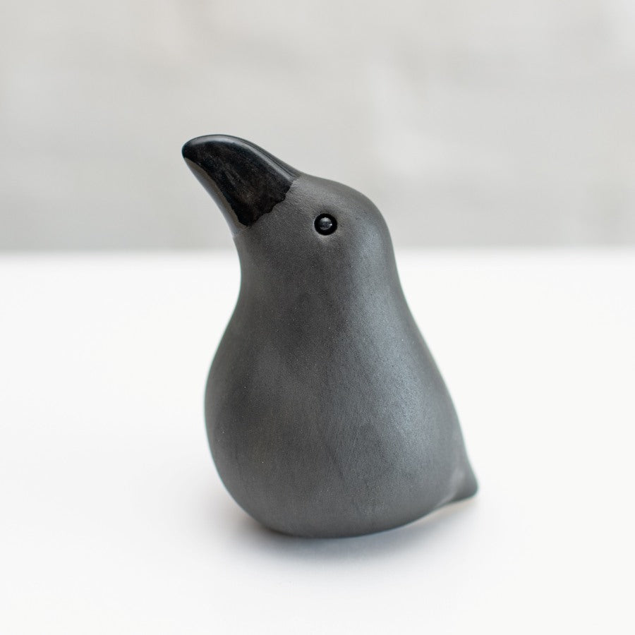 Small ceramic Raven sculpture against a white background