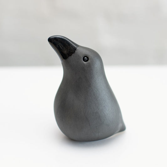 Small ceramic Raven sculpture against a white background