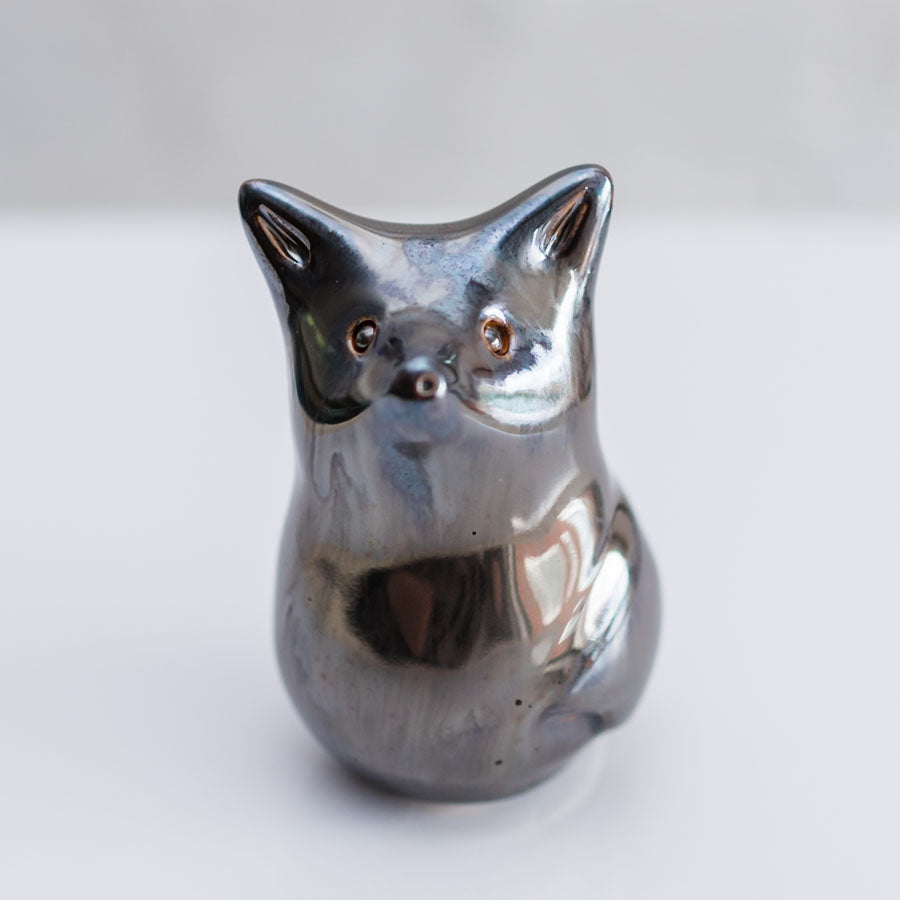 A small metallic fox figurine with a polished silver finish