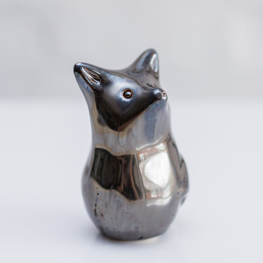 A small metallic fox figurine with a polished silver finis