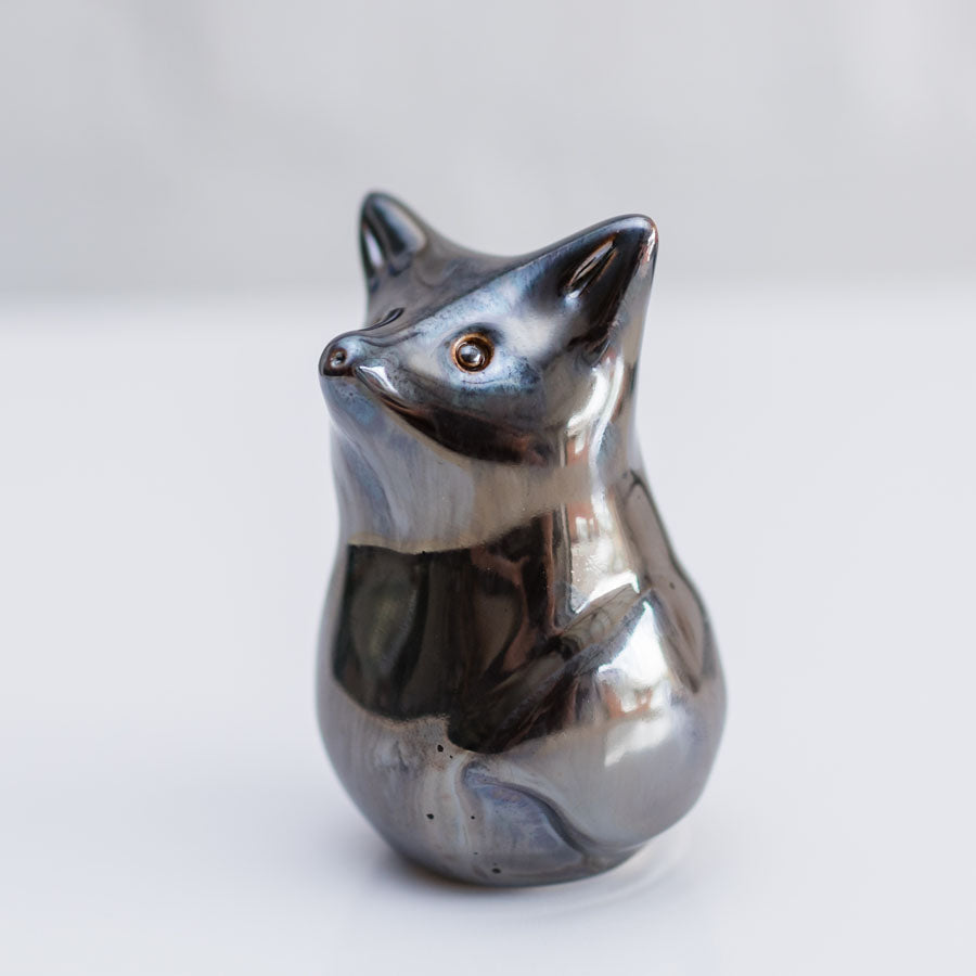 A small metallic fox figurine with a polished silver finish