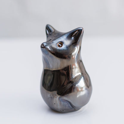 A small metallic fox figurine with a polished silver finish