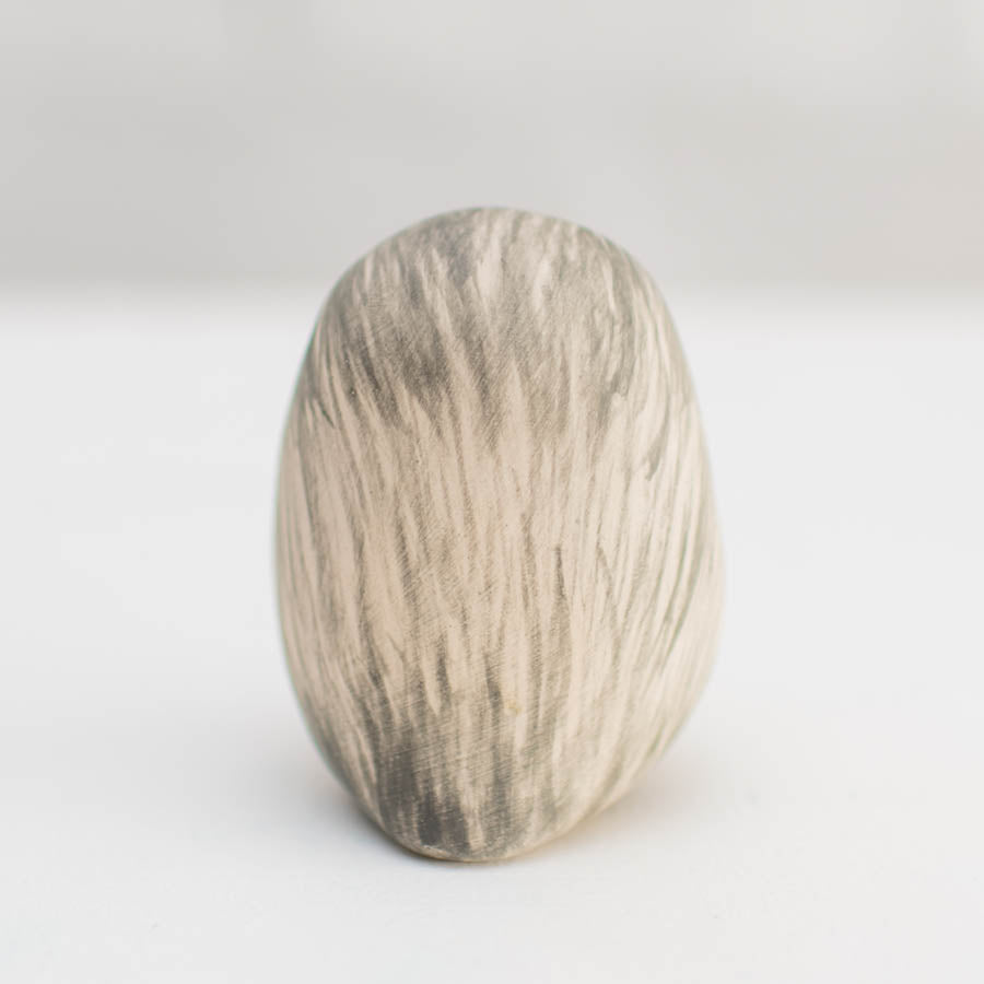 Snowy Owl Natural Finish, a small, egg-shaped ceramic with vertical grey and white brushstrokes