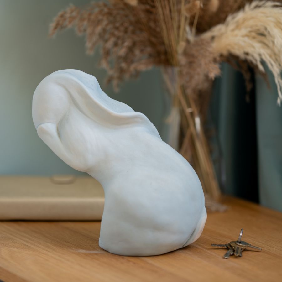 Washing my Hare Sculpture, a white ceramic hare with its head tilted back, on a wooden surface