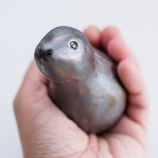 Metallic ceramic moongazing hare sculpture in a hand