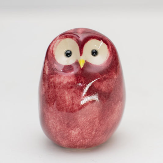 Wine red, glossy, small ceramic owl with a plain background
