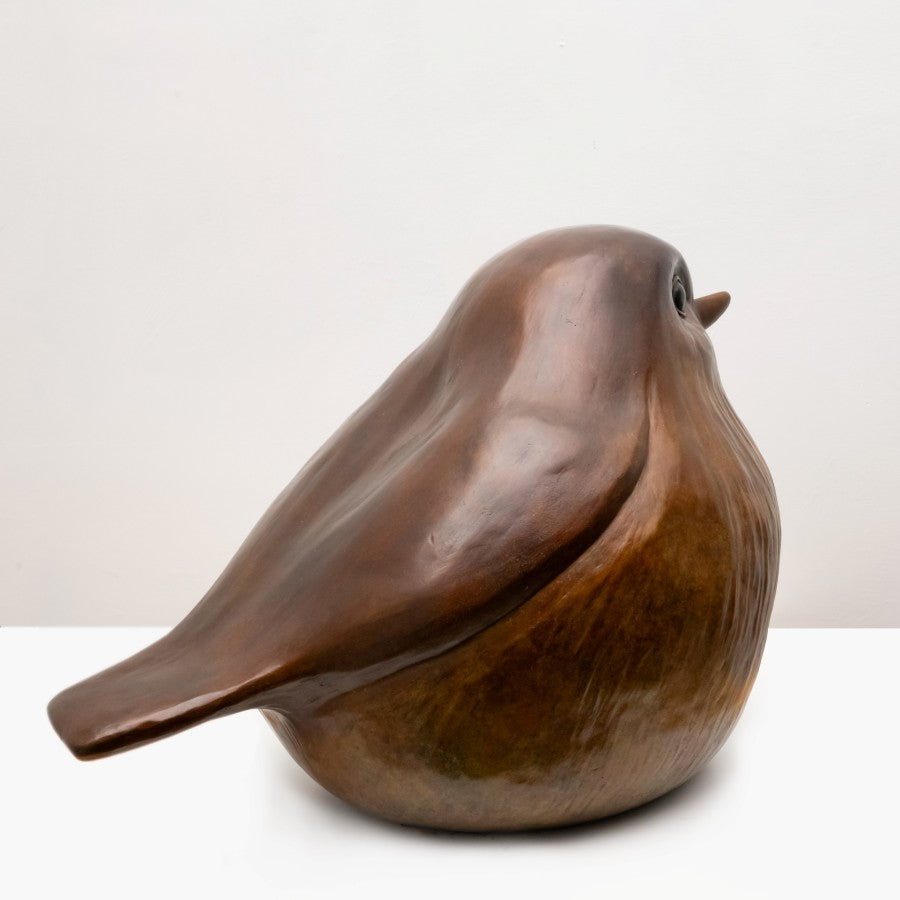 the right side view of a large bronze Robin against a white background