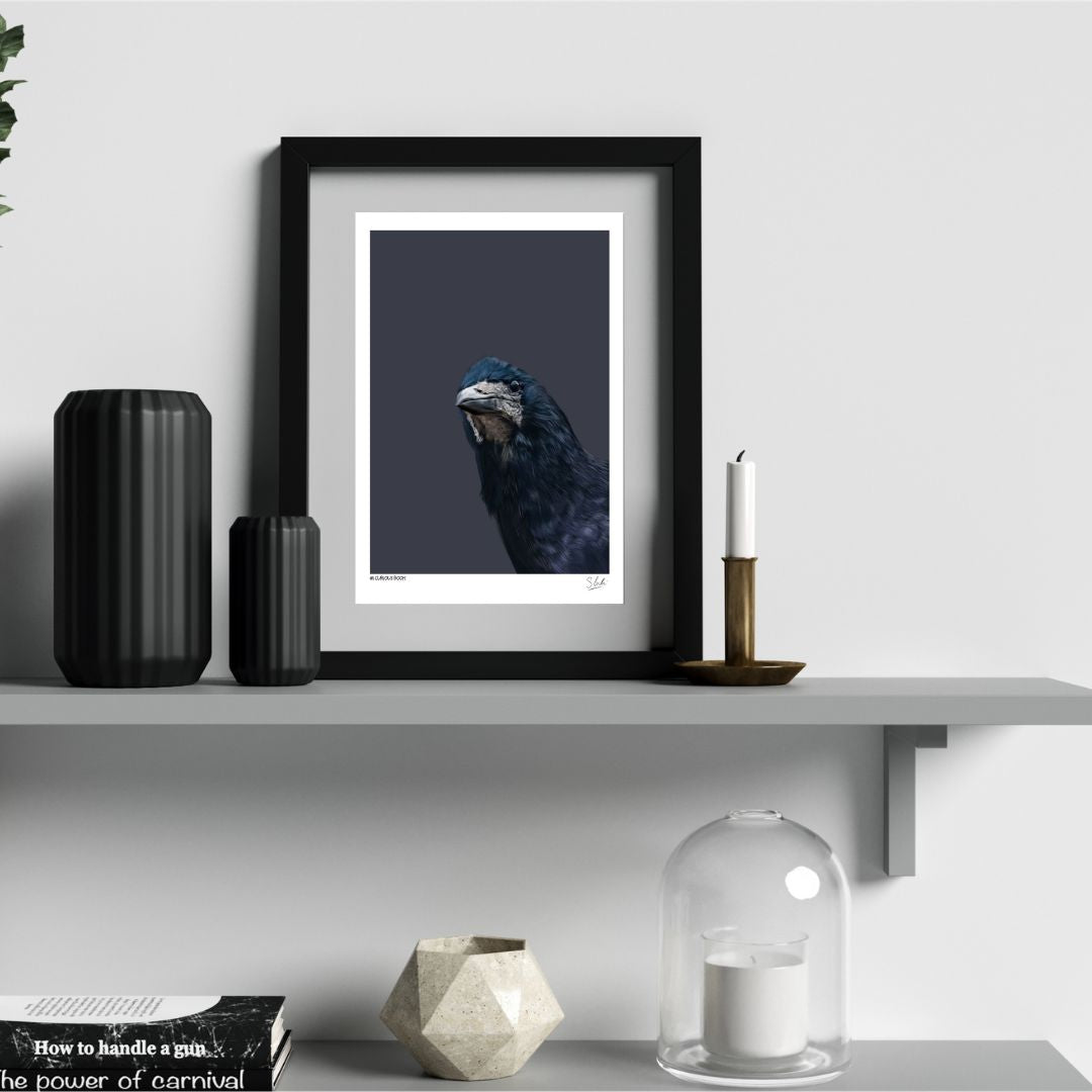 Rook artwork in a frame on a shelf with black vases and candles