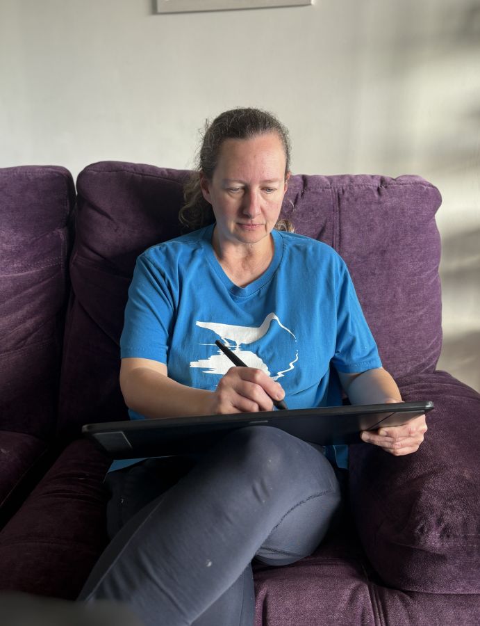 Sarah Brabbin drawing on her pad sat on her couch