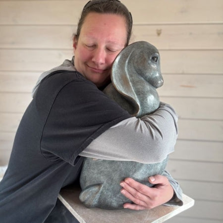 Sarah Brabbin hugging her bronze hare sculpture