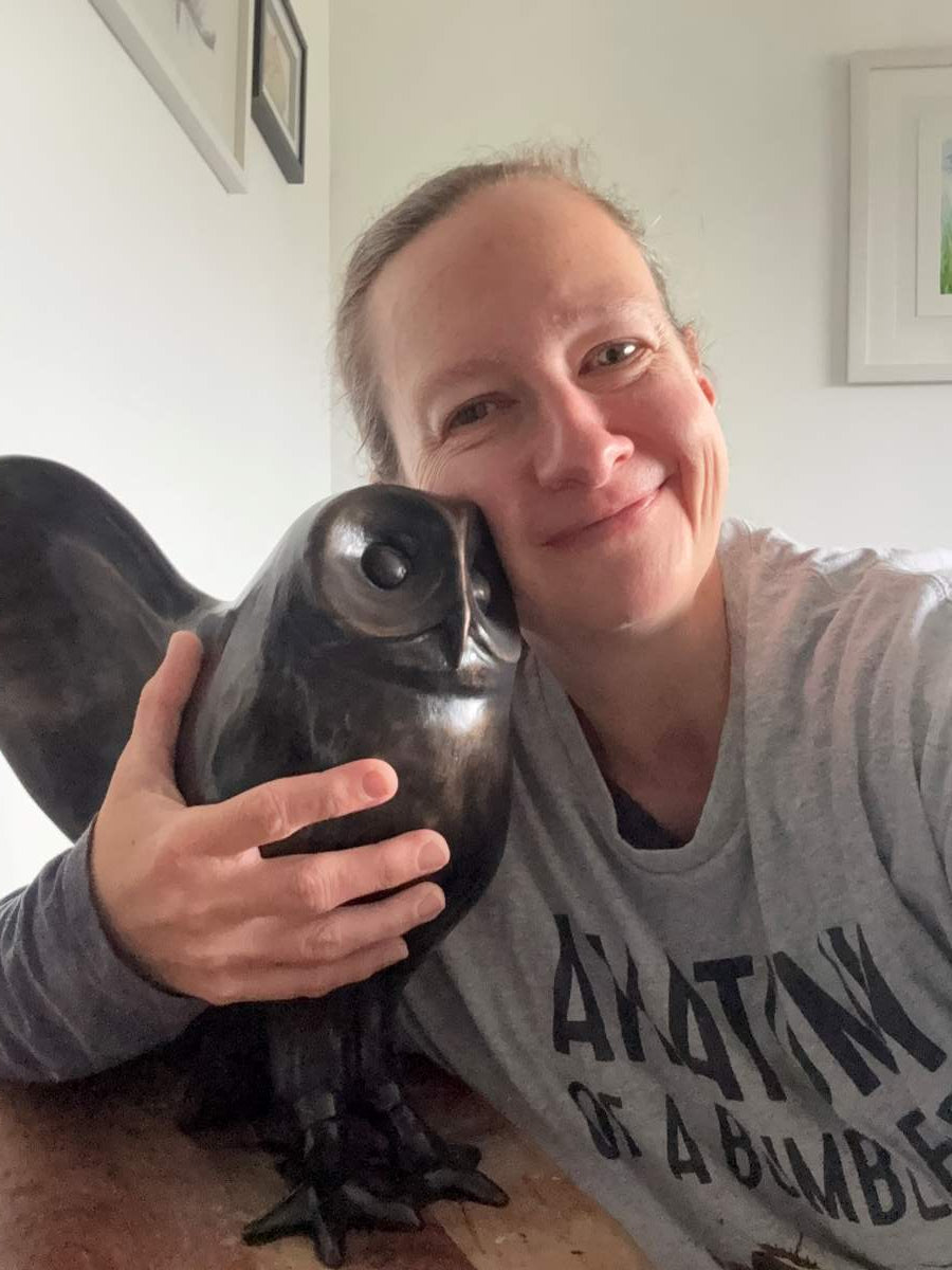 Sarah holding her bronze owl sculpture
