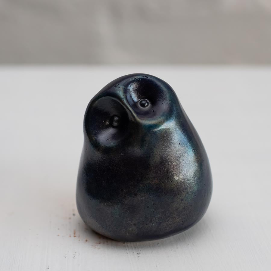 Deep blue small bronze owl sculpture on a white background
